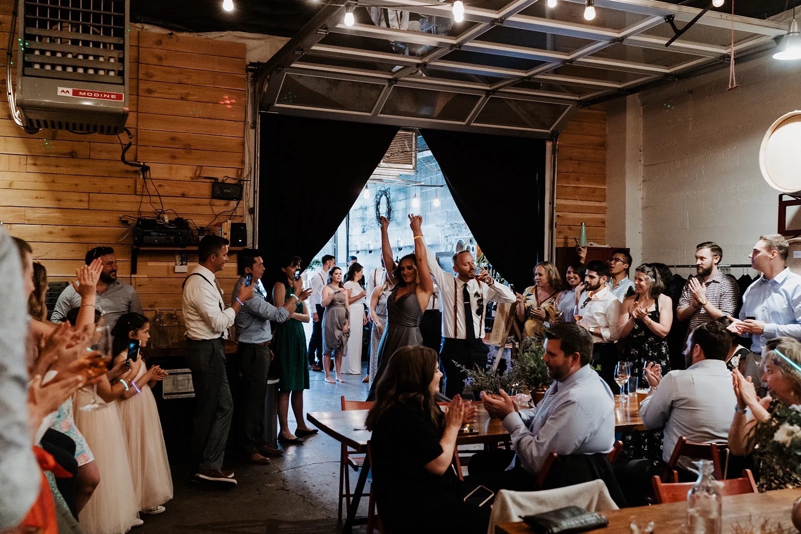 Newlyweds entering their reception in the ENSO Barrel Room