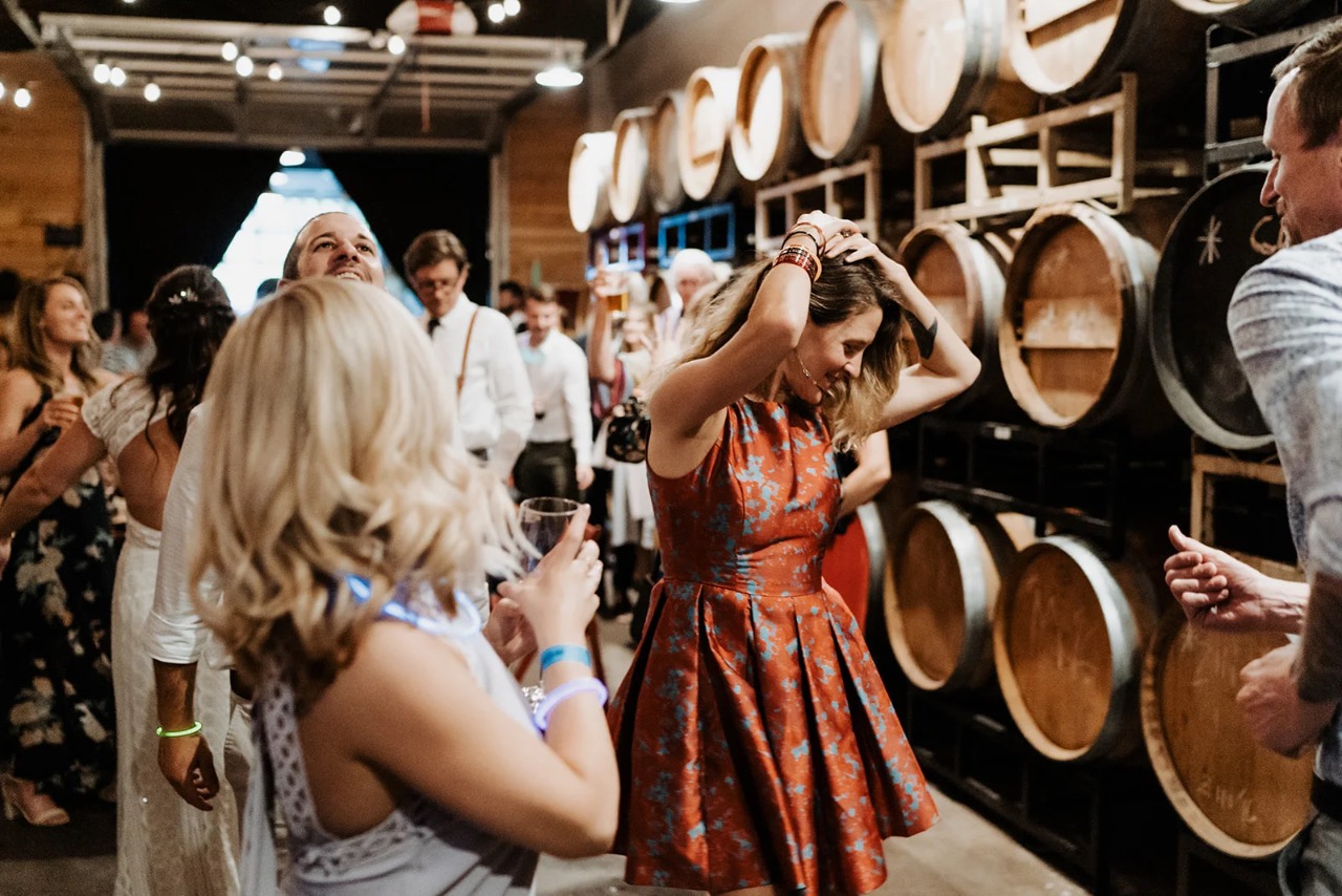 Guests celebrating among the wine barrels