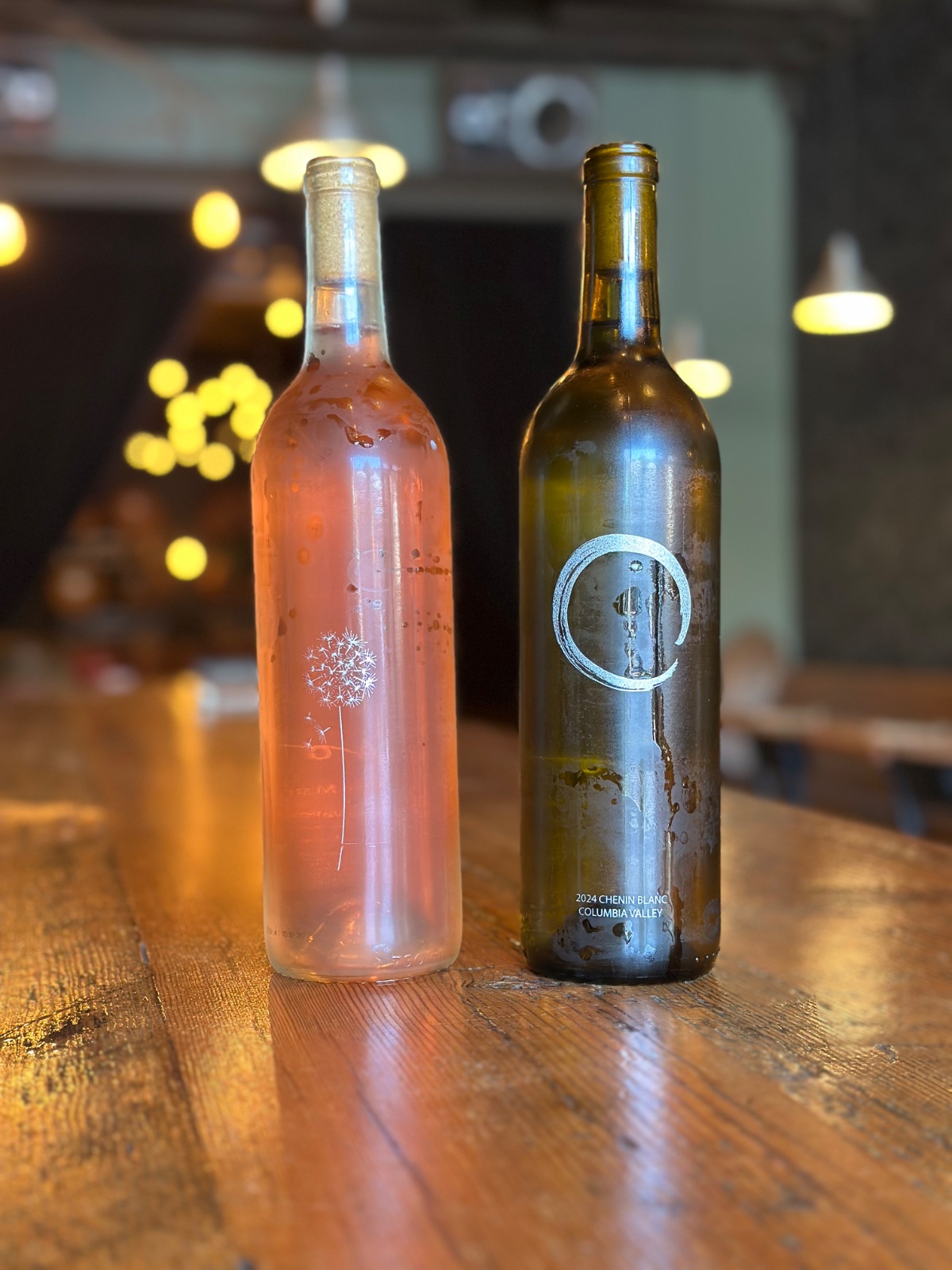 A bottle of rosé and a Chenin Blanc with the brushed ensō circle, side by side on the bar